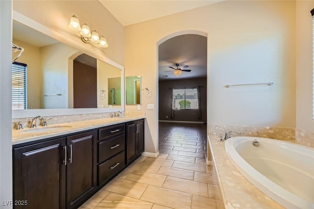 bathroom featuring tile patterned floors, ceiling fan, vanity, and a relaxing tiled tub