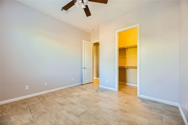 unfurnished bedroom featuring a closet, a spacious closet, and ceiling fan