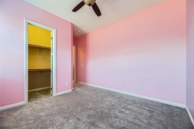 unfurnished bedroom featuring ceiling fan, a spacious closet, carpet floors, and a closet