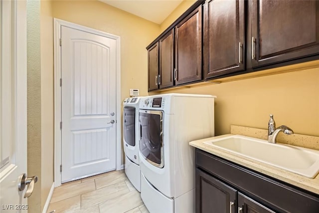 laundry room featuring separate washer and dryer, sink, and cabinets