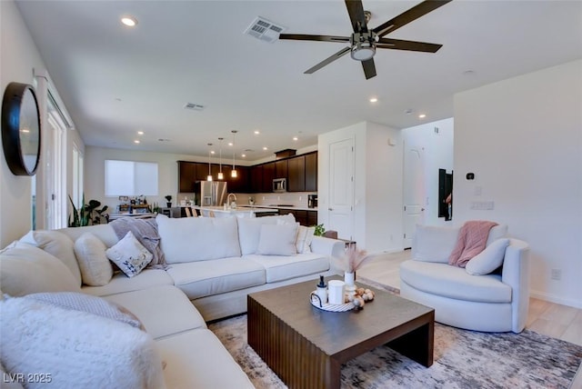 living room with light hardwood / wood-style floors and ceiling fan