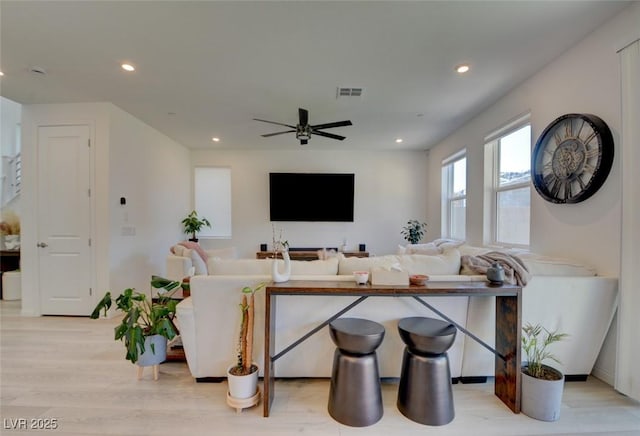 living room with light wood-type flooring and ceiling fan