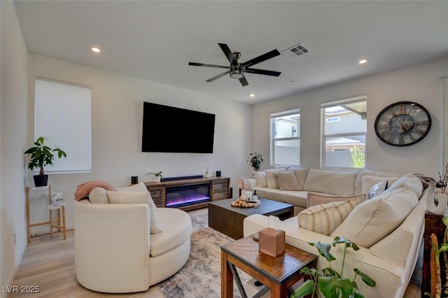 living room with ceiling fan and light hardwood / wood-style floors