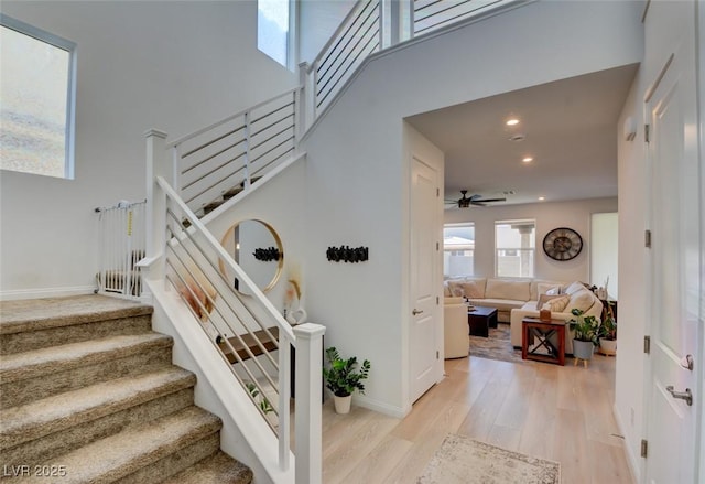 stairs featuring hardwood / wood-style floors and ceiling fan