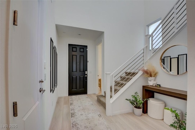 foyer entrance with light hardwood / wood-style flooring and a high ceiling