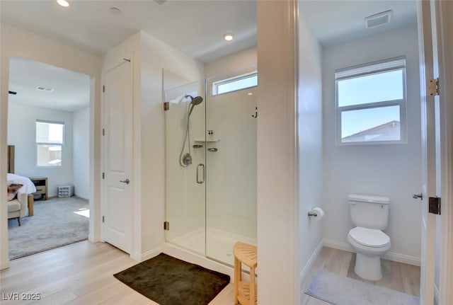 bathroom featuring walk in shower, hardwood / wood-style flooring, toilet, and plenty of natural light