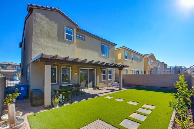 rear view of house featuring a patio area and a yard