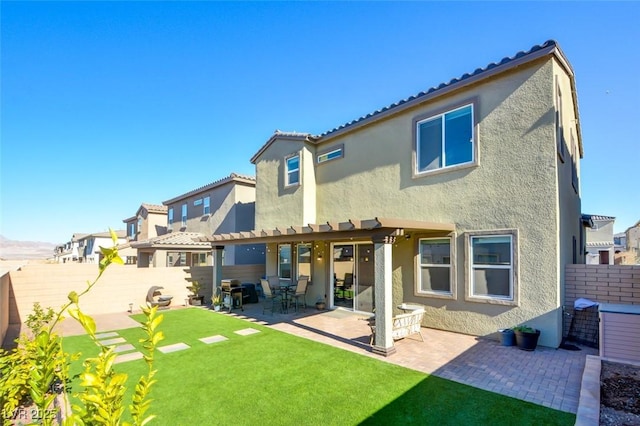 back of property with a pergola, a yard, and a patio