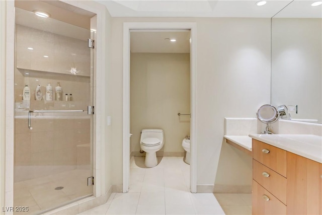 bathroom featuring tile patterned floors, vanity, a bidet, toilet, and a shower with shower door