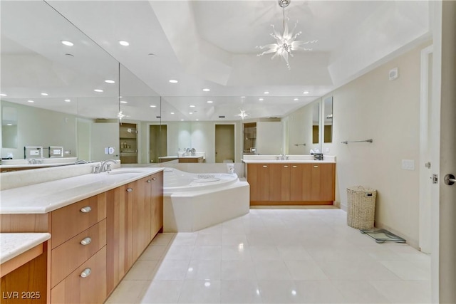 bathroom with tile patterned floors, vanity, a tub, and a notable chandelier