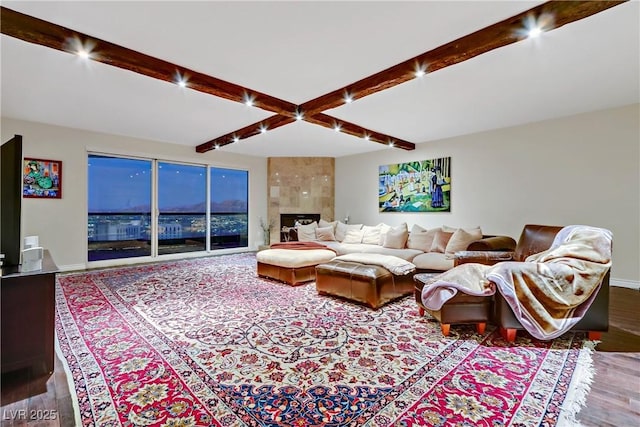 living room with beam ceiling, a premium fireplace, and hardwood / wood-style floors