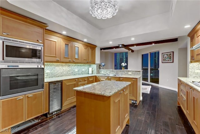 kitchen featuring kitchen peninsula, appliances with stainless steel finishes, tasteful backsplash, a center island, and wine cooler