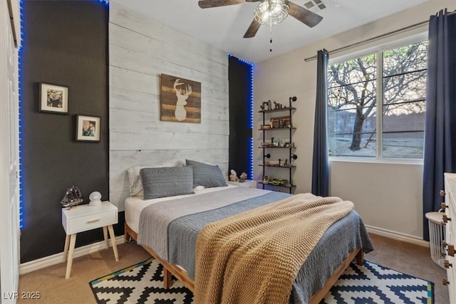 bedroom featuring carpet, ceiling fan, and wood walls