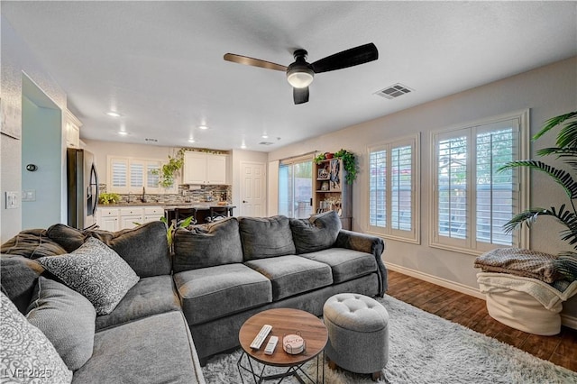 living room with ceiling fan, sink, and wood-type flooring