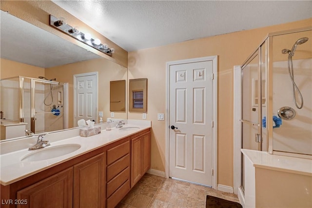 bathroom featuring vanity, a shower with shower door, and a textured ceiling