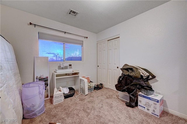 miscellaneous room with a textured ceiling and carpet floors