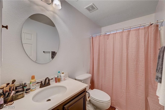 bathroom with vanity, curtained shower, and toilet