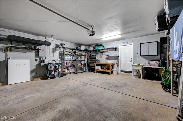 garage with a workshop area, white fridge, and a garage door opener