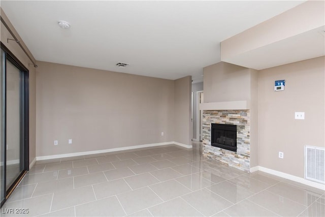 unfurnished living room featuring a stone fireplace and light tile patterned floors