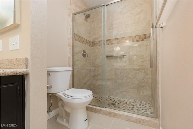 bathroom with tile patterned flooring, vanity, toilet, and a shower with shower door