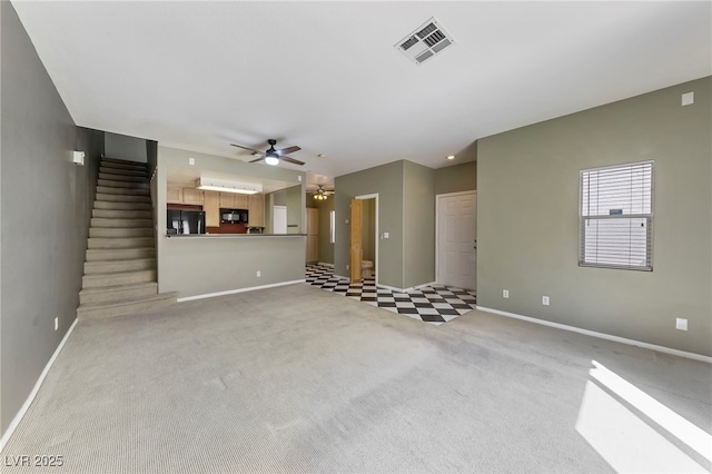 unfurnished living room featuring ceiling fan and light colored carpet