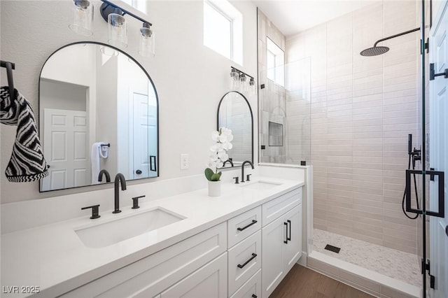 bathroom with vanity, wood-type flooring, and tiled shower