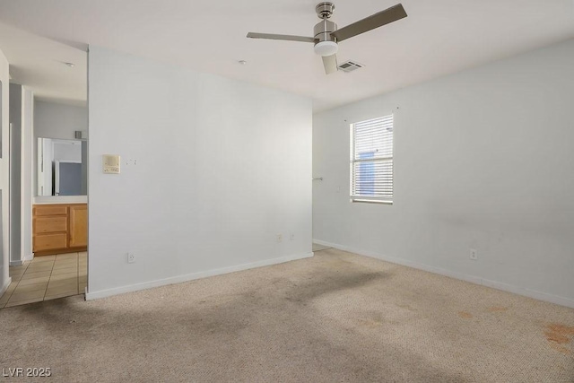 carpeted spare room featuring ceiling fan