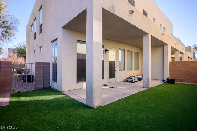 back of house featuring a patio area and a lawn