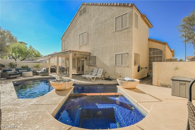 rear view of property with a pool with hot tub, a pergola, a patio, and outdoor lounge area