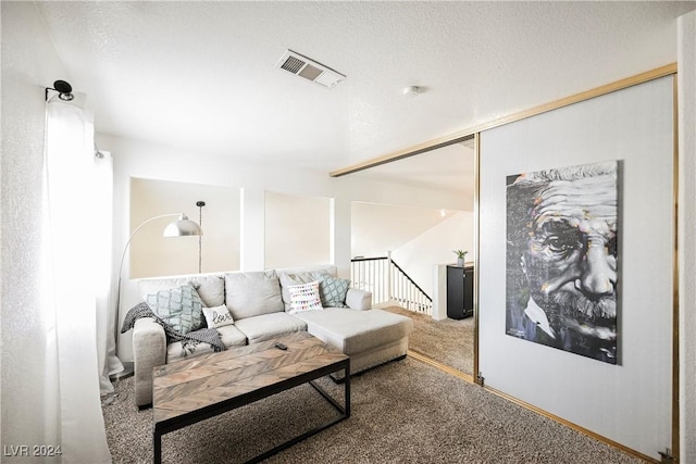 living room with a textured ceiling and carpet flooring