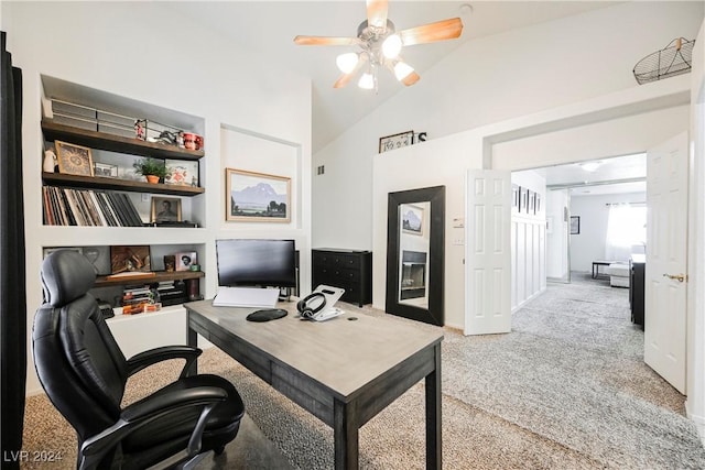 office space with ceiling fan, vaulted ceiling, built in features, and light colored carpet