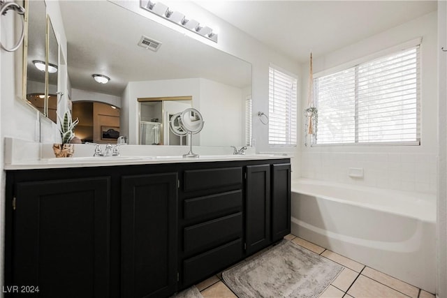 bathroom with tile patterned flooring, a bath, and vanity