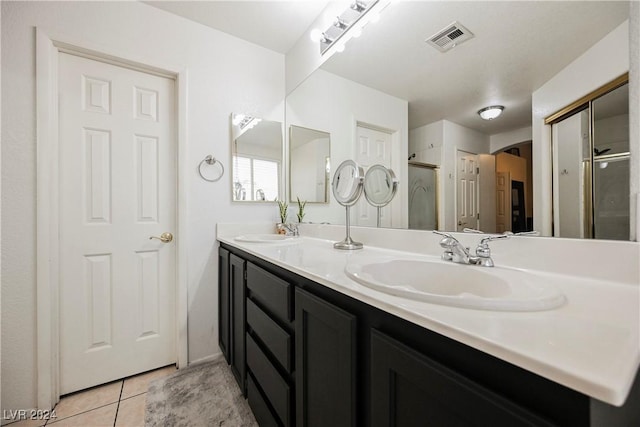 bathroom featuring a shower with door, vanity, and tile patterned floors