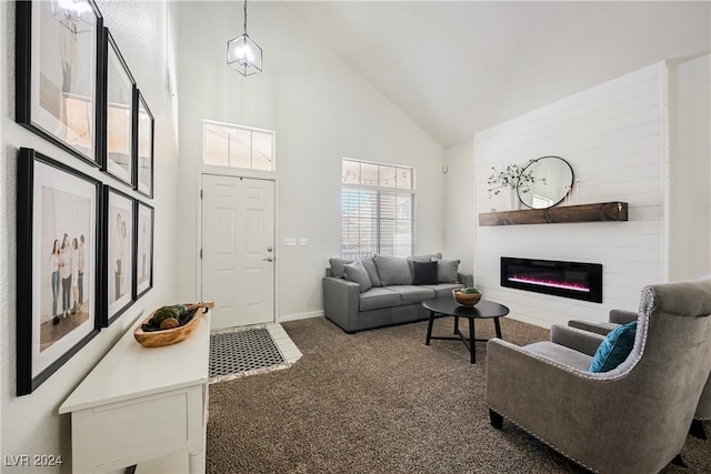 carpeted living room with a large fireplace and high vaulted ceiling