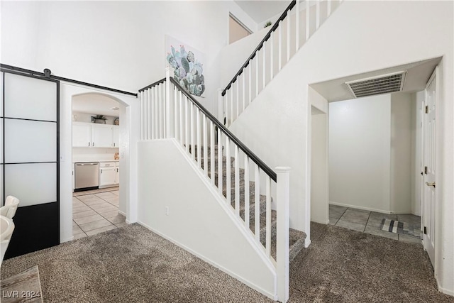 stairs featuring carpet floors and a barn door