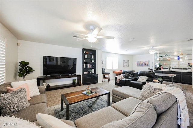 living room featuring a textured ceiling, carpet, and sink