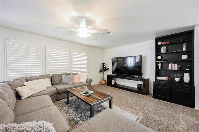 carpeted living room with ceiling fan