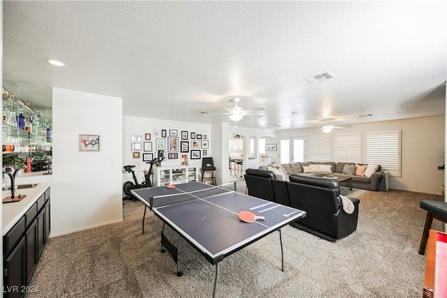 recreation room with ceiling fan and carpet floors