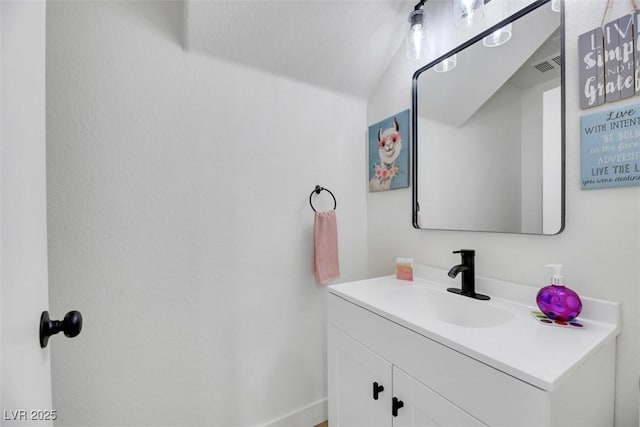 bathroom featuring vanity and lofted ceiling