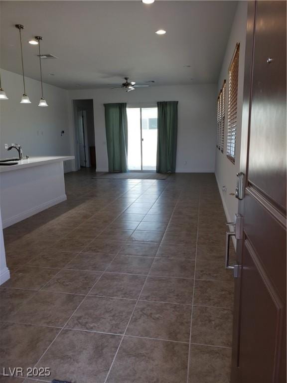 spare room with dark tile patterned flooring, ceiling fan, and sink