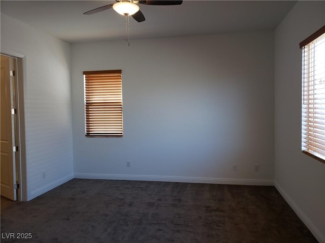 spare room with ceiling fan and dark colored carpet