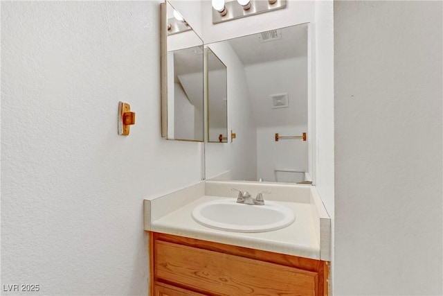 bathroom featuring vanity and toilet