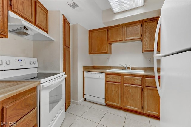 kitchen featuring white appliances, sink, and light tile patterned floors