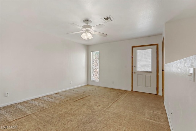 carpeted spare room featuring plenty of natural light and ceiling fan