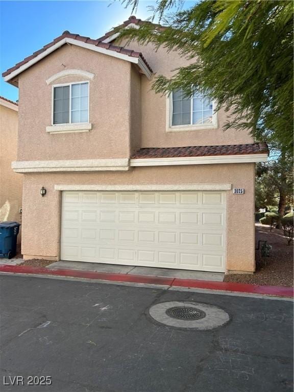 3025 Sunrise Bay Ave, North Las Vegas, NV 89031 - view of front of property featuring a tile roof, stucco siding, an attached garage, and asphalt driveway