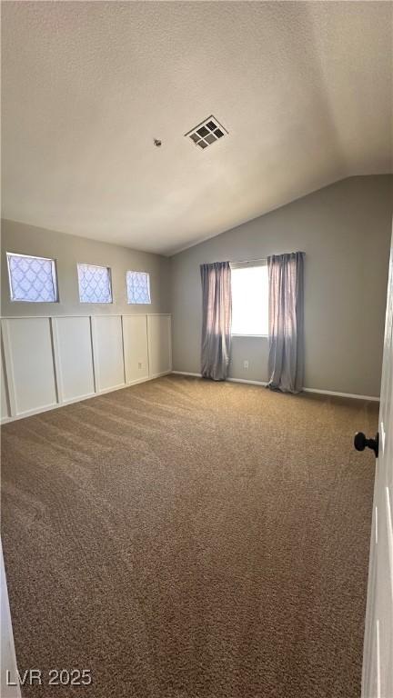 3025 Sunrise Bay Ave, North Las Vegas, NV 89031 - unfurnished room featuring vaulted ceiling, carpet flooring, a textured ceiling, and baseboards