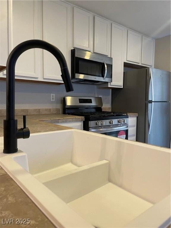 3025 Sunrise Bay Ave, North Las Vegas, NV 89031 - kitchen featuring stainless steel appliances, white cabinets, and light countertops
