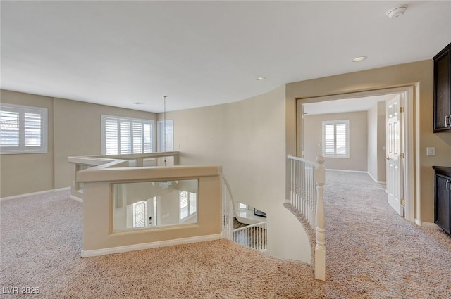 hallway featuring light colored carpet