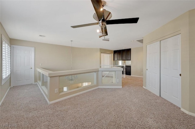 interior space with light carpet and ceiling fan