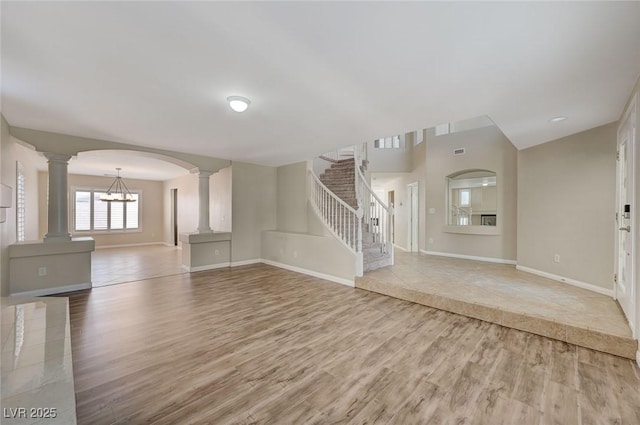 unfurnished living room featuring wood-type flooring and a notable chandelier